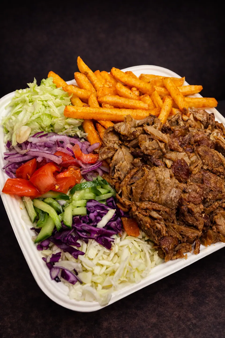 Teller mit Dönerfleisch, Pommes und Gemüse zum Mitnehmen